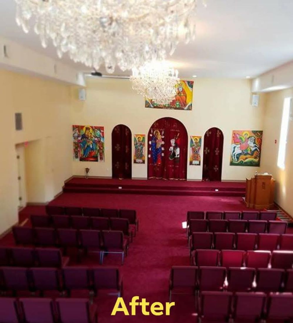 Same assembly hall finished, with painted walls, decorative arches, seating, and chandeliers installed